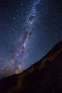 Low angle view of silhouette mountain against sky at night