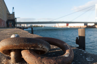 Close-up of rusty chain on bridge against sky