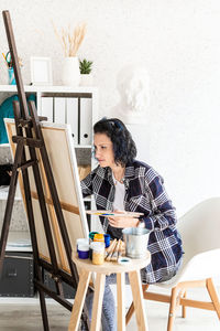 Woman sitting on table at home