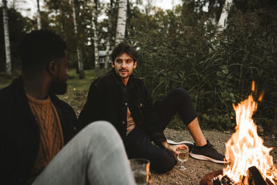 Young men sitting in forest