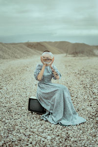 Full length of girl sitting on sand