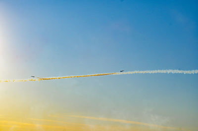 Low angle view of vapor trail against blue sky