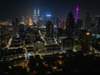 Illuminated cityscape against sky at night