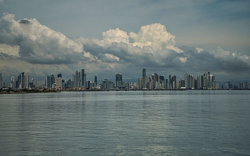 Sea by buildings against sky in city, skyline of panama