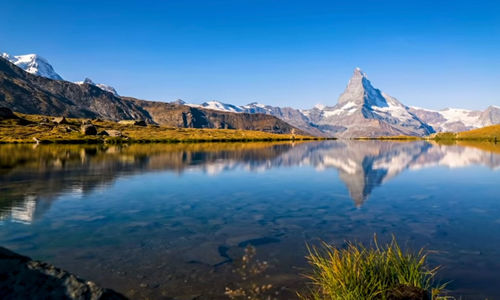 Scenic view of lake and mountains against blue sky