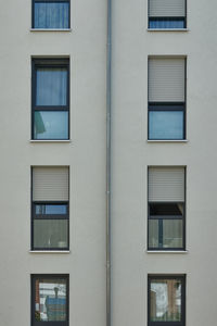 Strict looking perfectly rectangular facade of a residential building with windows and shutters