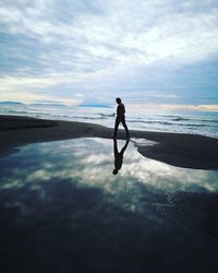 Silhouette man on beach against sky