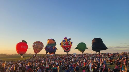 Rear view of woman with balloons against clear sky