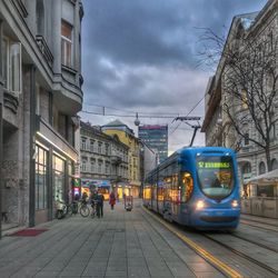 Cars on train in city against sky