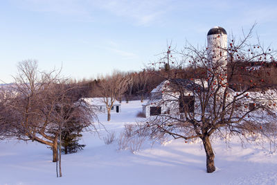 Village farm with white buildings and tall silo seen during a winter morning, island of orleans