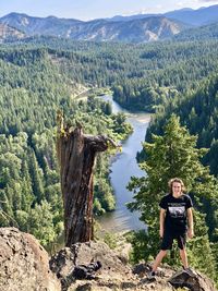 Man standing by tree against mountains