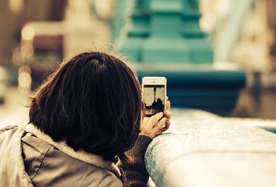 Young woman photographing through smart phone