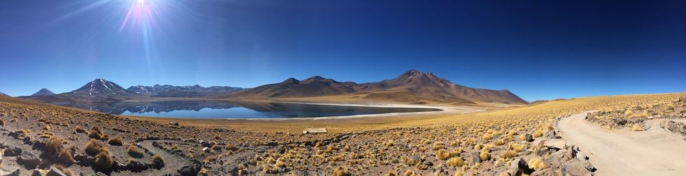 Panoramic view of desert against blue sky