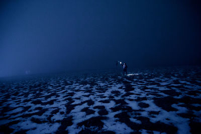 Man surfing in sea against sky during winter