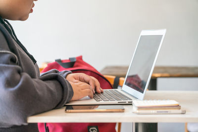 Side view of man using laptop on table