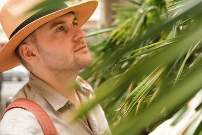 Portrait of young man tourist wearing sunhat looking away