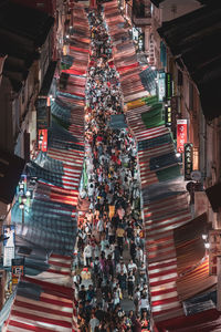 High angle view of illuminated street amidst buildings at night