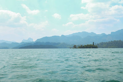 Scenic view of sea by mountains against sky