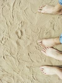 Low section of people on sand at beach