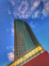 Low angle view of modern building against cloudy sky