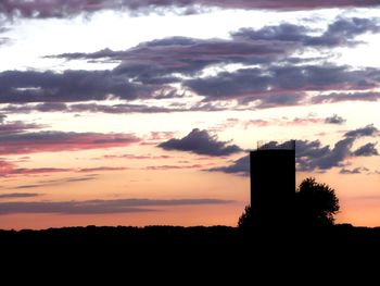 Silhouette building against sky during sunset