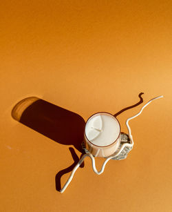 High angle view of drink on table against orange background