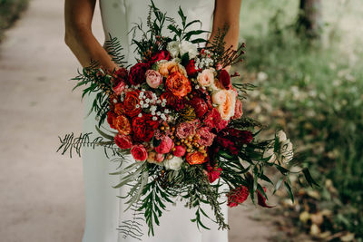 Low angle view of person holding flowering plant