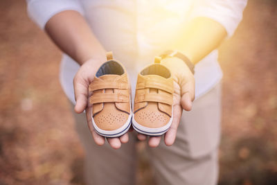 Midsection of man holding baby booties