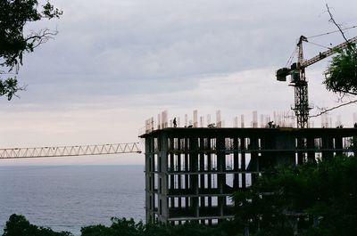 Built structure by sea against sky