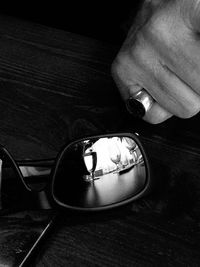 Close-up of hand holding camera on table