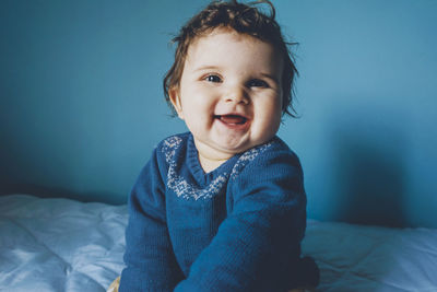 Portrait of cute baby girl on bed at home