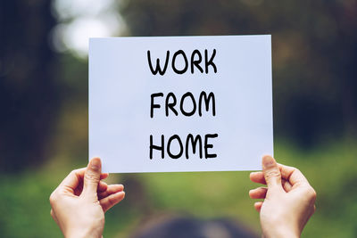 Close-up of hand holding text on paper