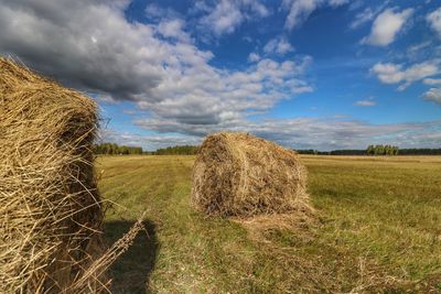 Hay bales on field against sky