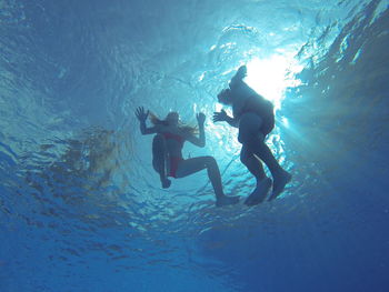 Low angle view of friends swimming in sea