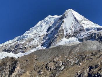 Scenic view of snowcapped mountains against clear blue sky