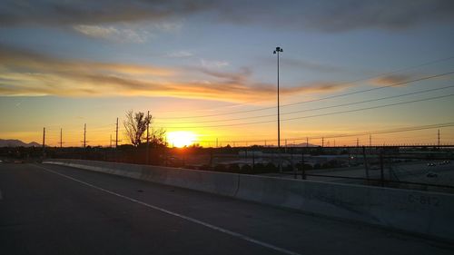 Silhouette road against sky during sunset