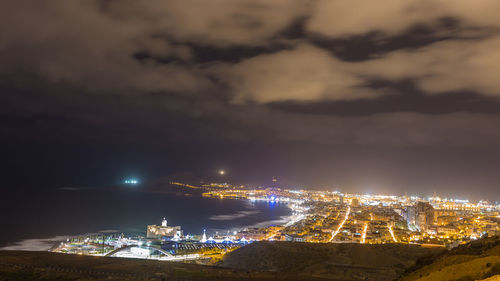 High angle view of illuminated buildings against sky at night