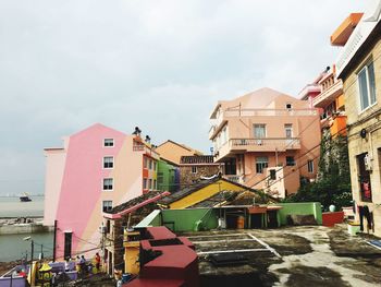 Houses by street in town against sky