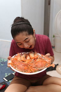 Smiling woman holding prawns