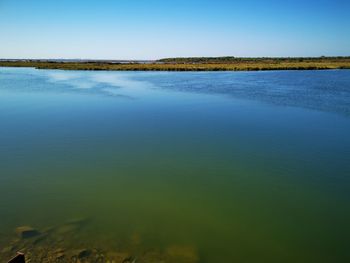 Scenic view of lake against clear blue sky