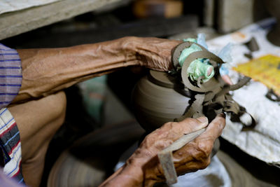 Midsection of man working on pottery wheel