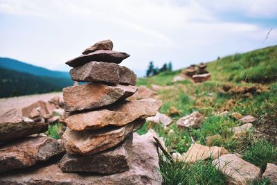 Stack of rocks on land against sky