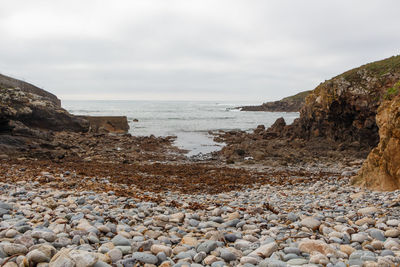 Rocks on beach against sky