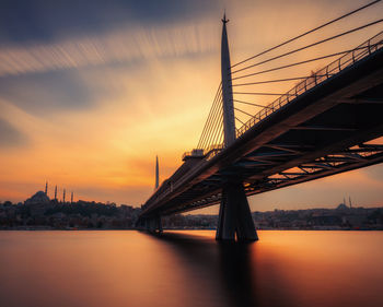 Bridge over river at sunset