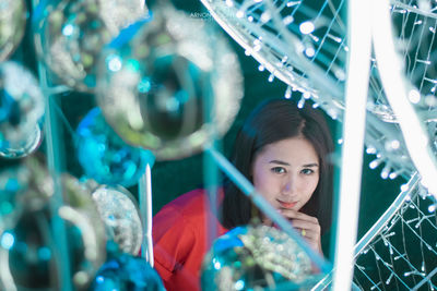 Portrait of smiling young woman seen through illuminated lights