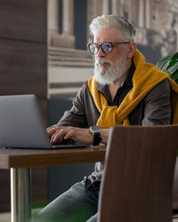 Senior man using laptop while sitting at table