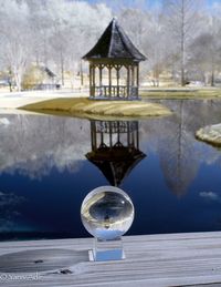 Close-up of gazebo on table by lake against sky