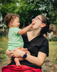 Smiling mother and son sitting outdoors