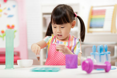 Cute girl playing with toy at home