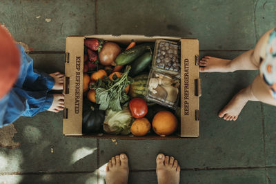 Overhead view of csa farmers box full of produce on front porch